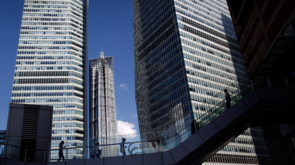 People walk at the financial district of Pudong in Shanghai